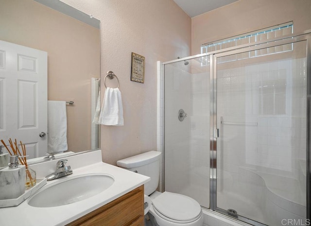 bathroom featuring toilet, vanity, and walk in shower