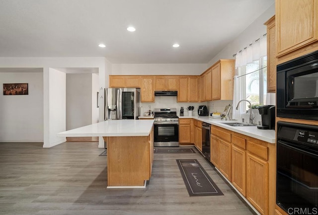 kitchen with dark wood-type flooring, black appliances, sink, a kitchen island, and a kitchen bar