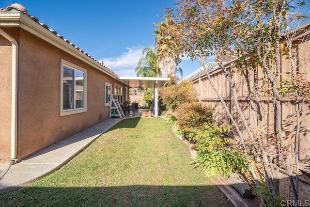 view of yard with ceiling fan and a patio area