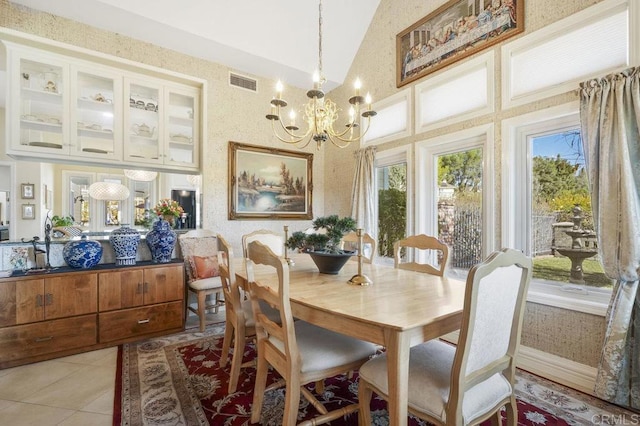 tiled dining area featuring a notable chandelier, a wealth of natural light, and vaulted ceiling