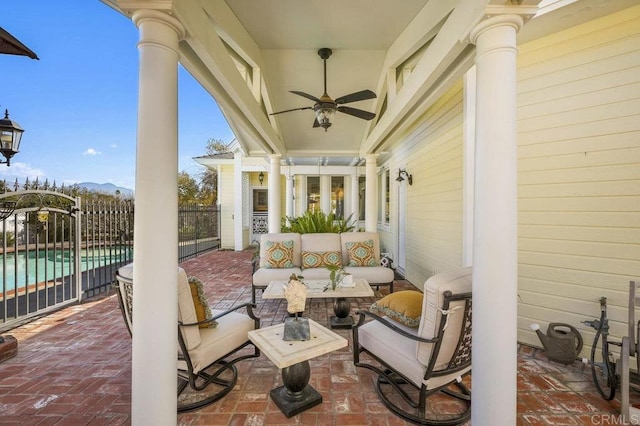 view of patio / terrace with outdoor lounge area, a mountain view, ceiling fan, and a fenced in pool