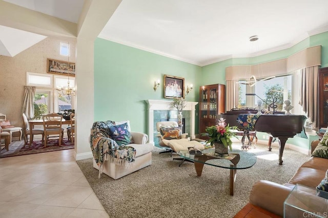 living room featuring a chandelier, light tile patterned floors, a tile fireplace, and ornamental molding