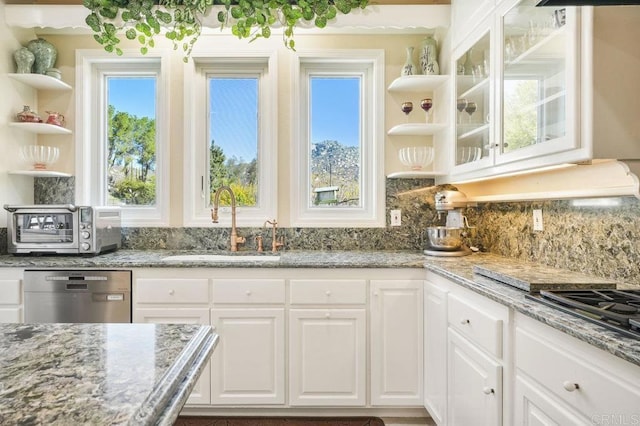 kitchen with stainless steel dishwasher, a healthy amount of sunlight, white cabinetry, and sink