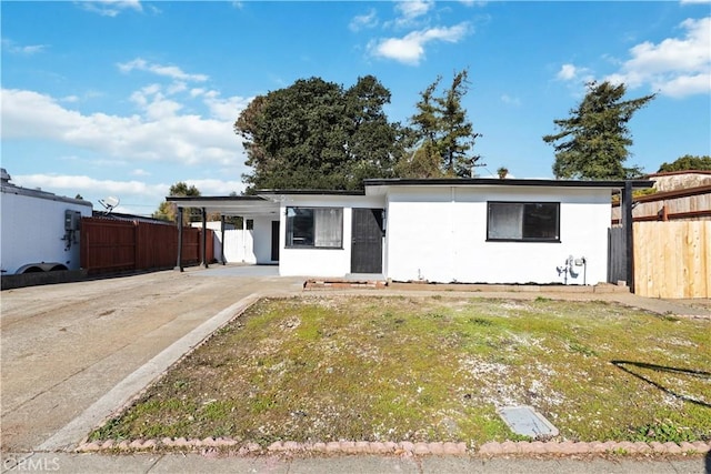 ranch-style home featuring a carport and a front lawn