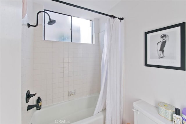 bathroom featuring shower / bath combo with shower curtain and toilet