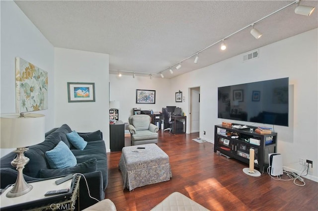 living room with dark hardwood / wood-style flooring, rail lighting, and a textured ceiling