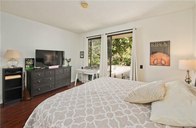 bedroom with dark hardwood / wood-style floors, access to exterior, and a textured ceiling