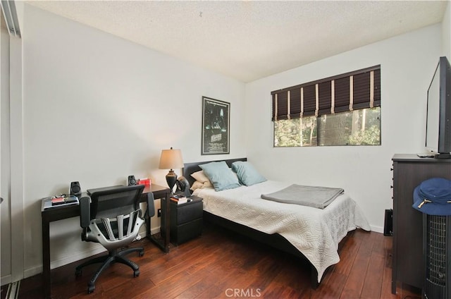 bedroom featuring dark hardwood / wood-style floors and a textured ceiling