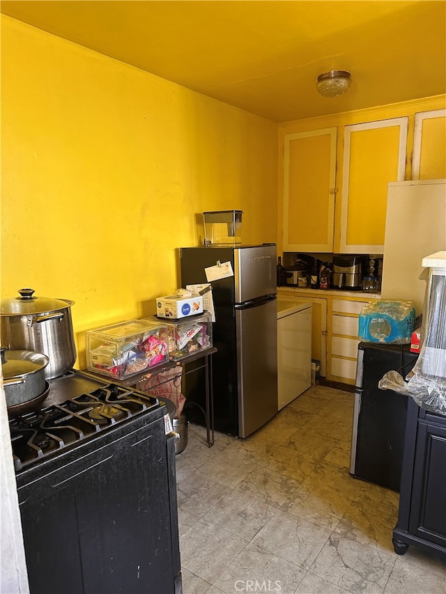 kitchen with stainless steel refrigerator and black gas stove