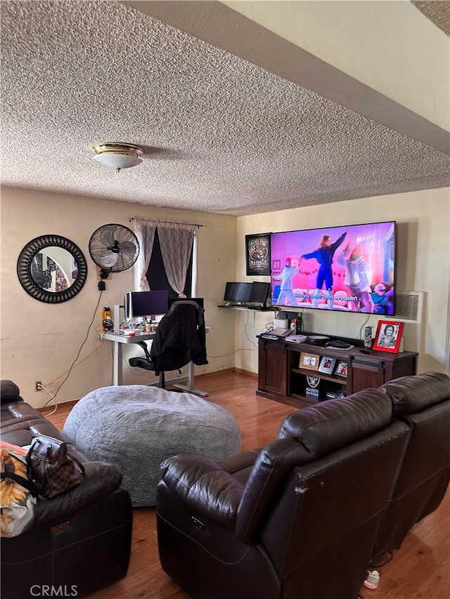 living room featuring wood-type flooring and a textured ceiling