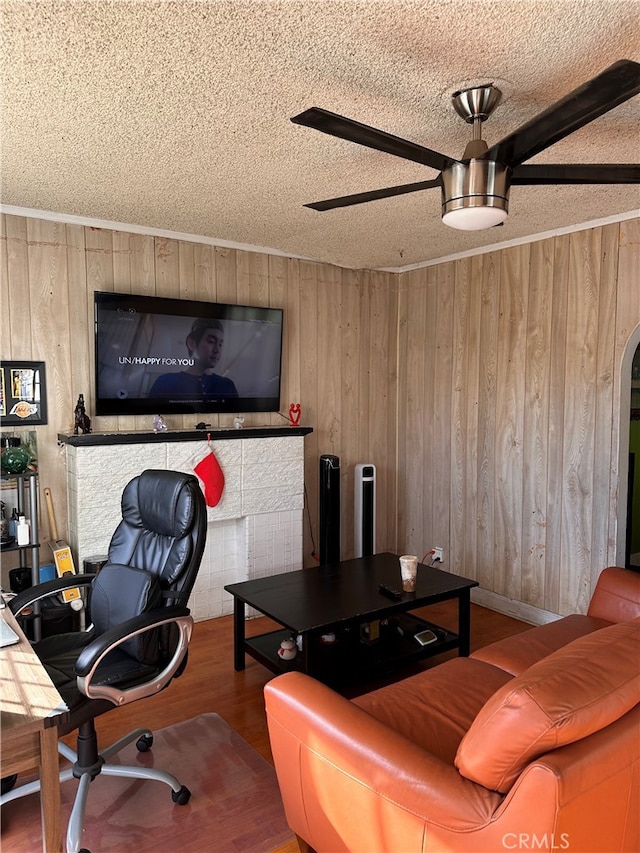 office area featuring hardwood / wood-style floors, ceiling fan, and wooden walls