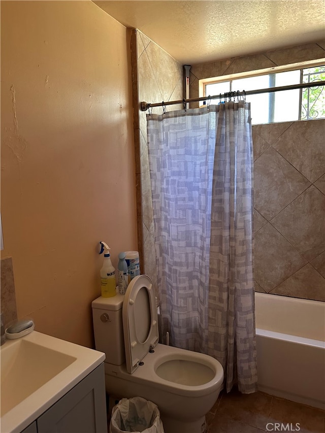 full bathroom featuring shower / bath combo, tile patterned floors, sink, toilet, and a textured ceiling