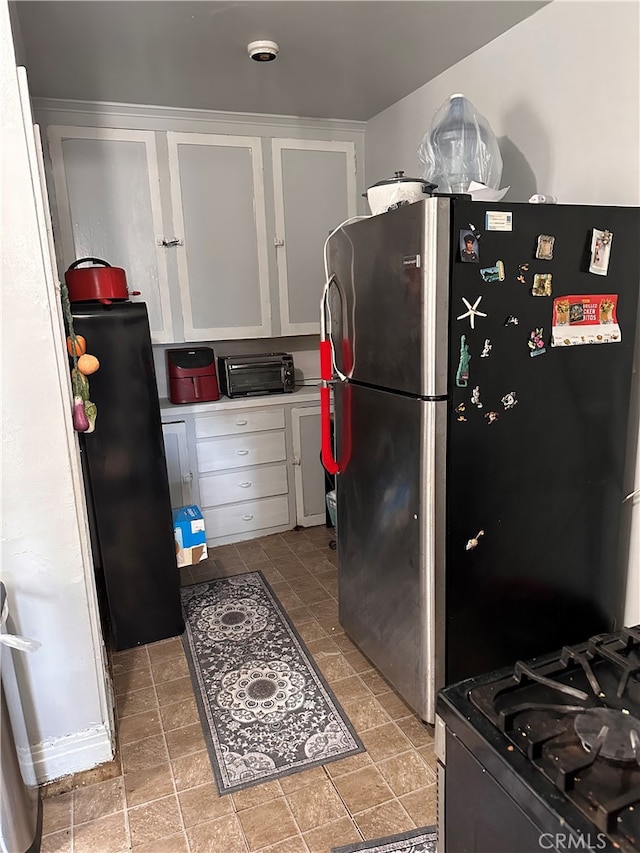 kitchen featuring white cabinets and stainless steel refrigerator