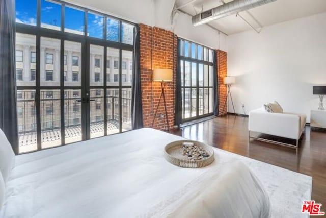 bedroom with a towering ceiling and dark hardwood / wood-style floors