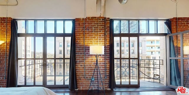 interior space featuring a wealth of natural light, dark hardwood / wood-style flooring, and brick wall