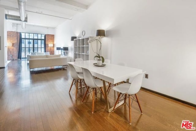 dining area with beam ceiling and wood-type flooring