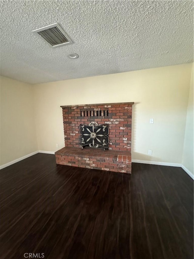 unfurnished living room with dark hardwood / wood-style floors and a textured ceiling