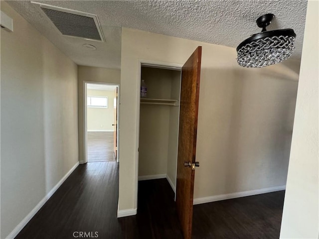 corridor featuring dark hardwood / wood-style floors and a textured ceiling