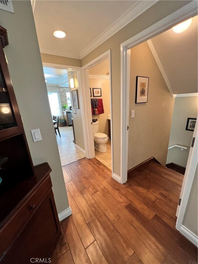 hall featuring ornamental molding and light hardwood / wood-style floors