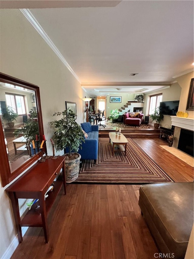 living room with a healthy amount of sunlight, wood-type flooring, and crown molding