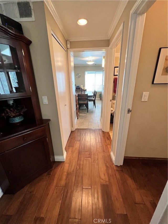 hall with ornamental molding and hardwood / wood-style floors