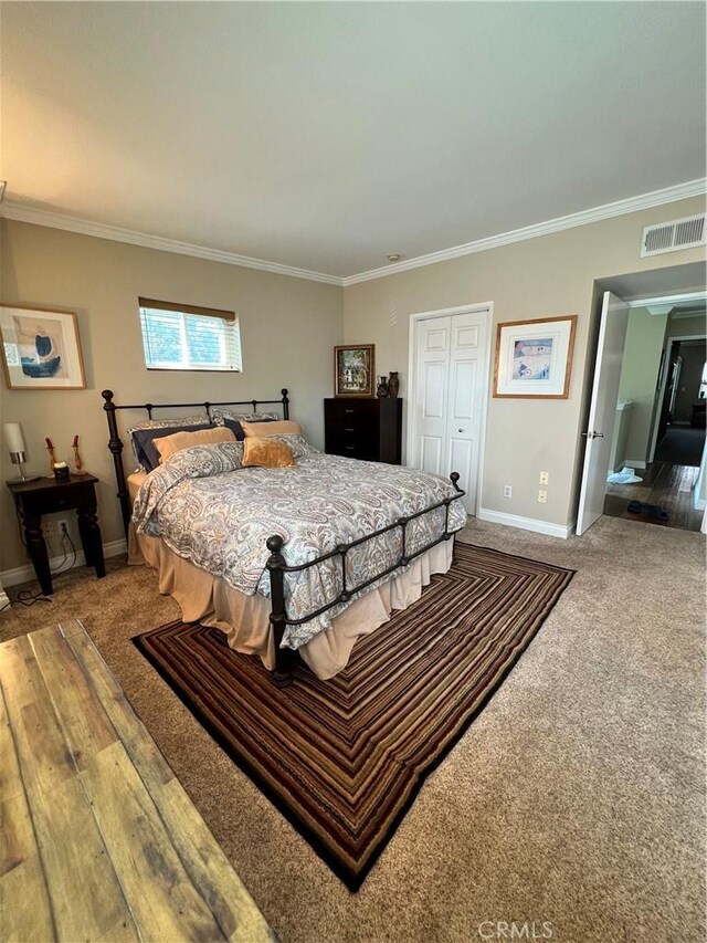 carpeted bedroom featuring a closet and ornamental molding