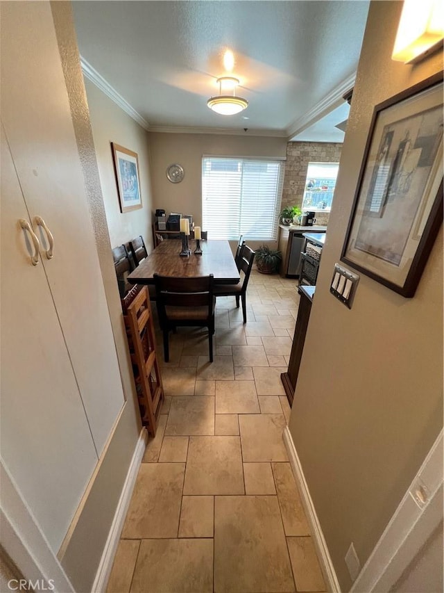 hall featuring light tile patterned floors and ornamental molding