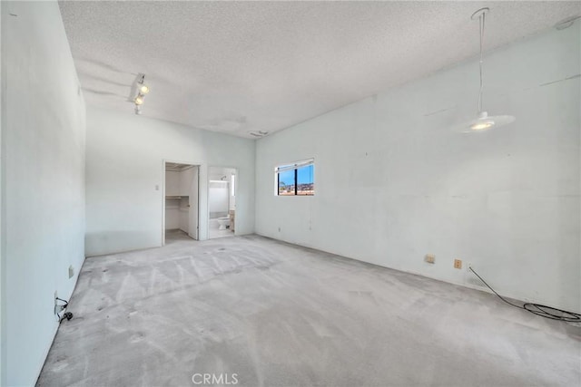 empty room featuring light colored carpet and a textured ceiling