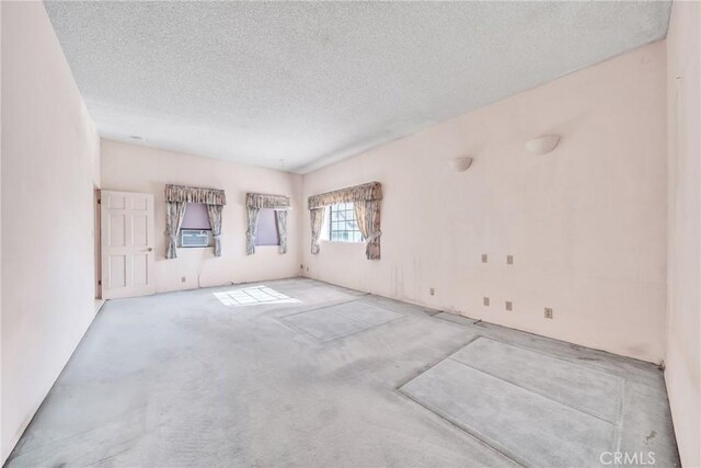 carpeted spare room with a textured ceiling