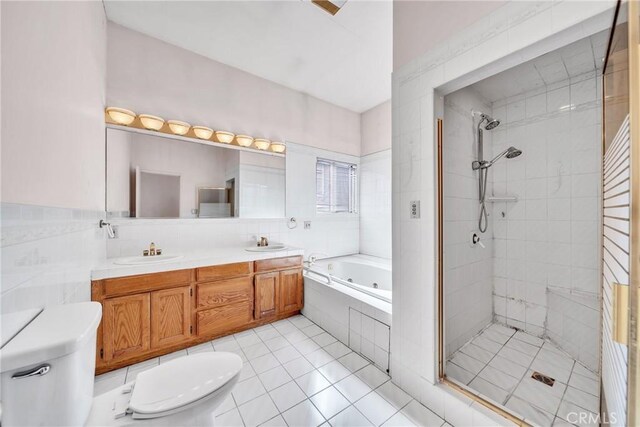 full bathroom with tile patterned floors, vanity, shower with separate bathtub, and toilet