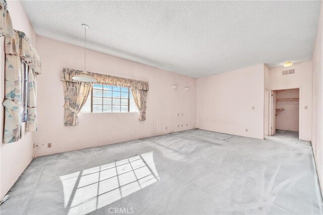 carpeted empty room featuring a textured ceiling