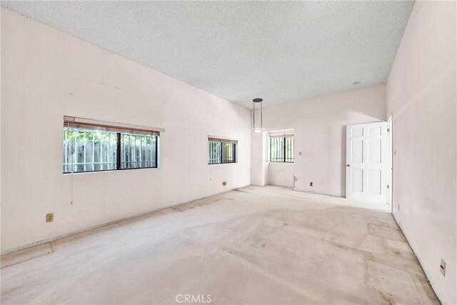 unfurnished room featuring light carpet and a textured ceiling