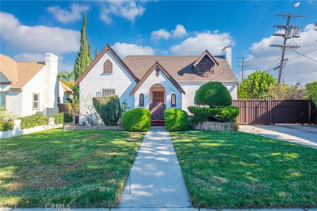 tudor home featuring a front lawn