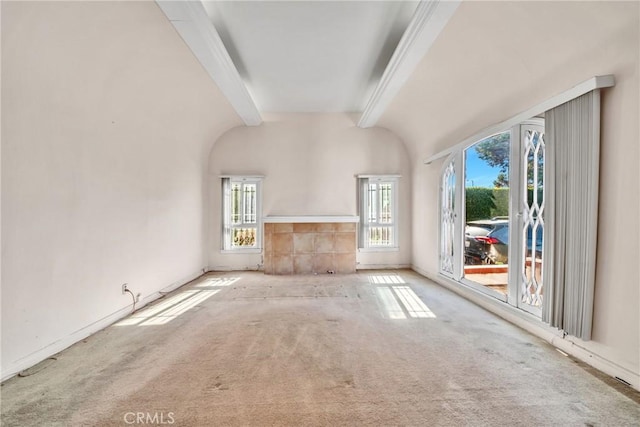 unfurnished living room featuring vaulted ceiling with beams and light colored carpet