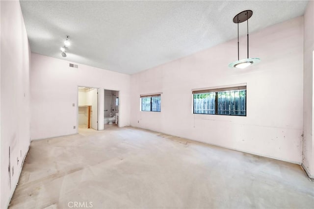 empty room with light colored carpet and a textured ceiling