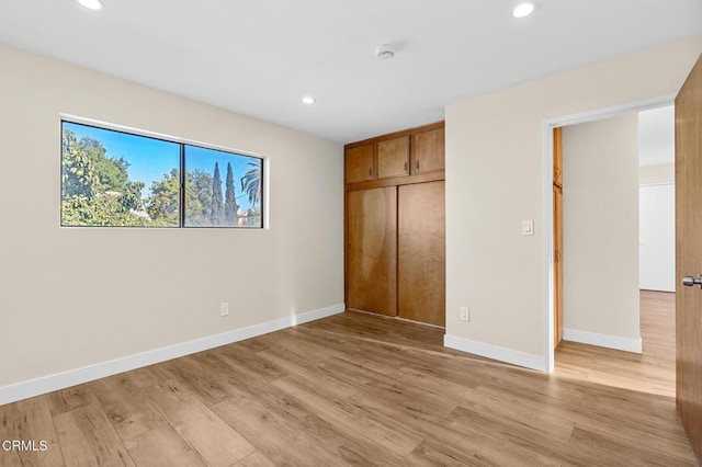 unfurnished bedroom featuring light hardwood / wood-style floors and a closet