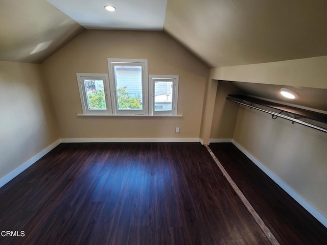 additional living space featuring lofted ceiling and dark wood-type flooring