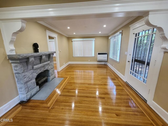 living room featuring a stone fireplace, light hardwood / wood-style flooring, heating unit, and ornamental molding