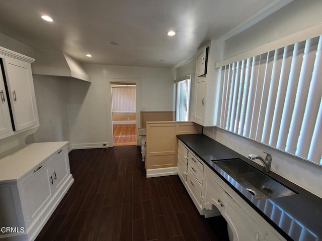 kitchen with dark hardwood / wood-style flooring, white cabinets, and sink