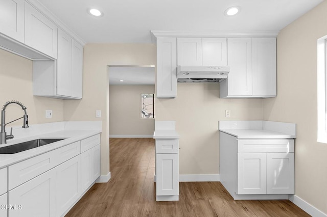 kitchen with white cabinetry, sink, plenty of natural light, and light wood-type flooring