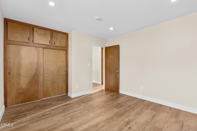 unfurnished bedroom featuring a closet and light wood-type flooring