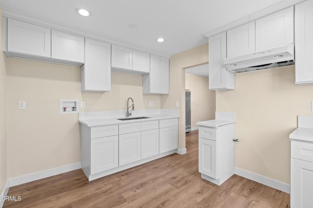 kitchen featuring white cabinetry, light hardwood / wood-style flooring, sink, and ventilation hood