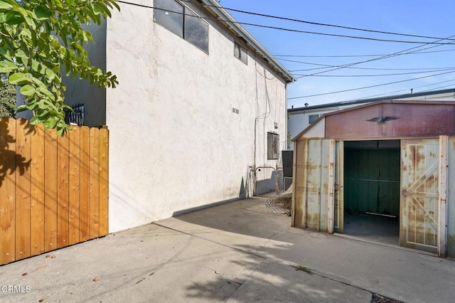 view of home's exterior with a storage unit and a patio area