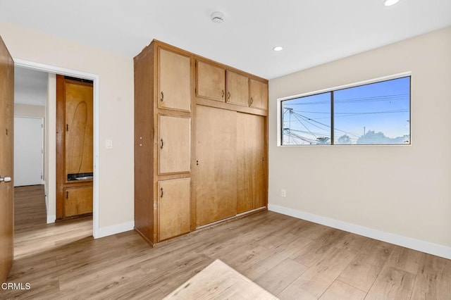 unfurnished bedroom featuring light hardwood / wood-style flooring and a closet