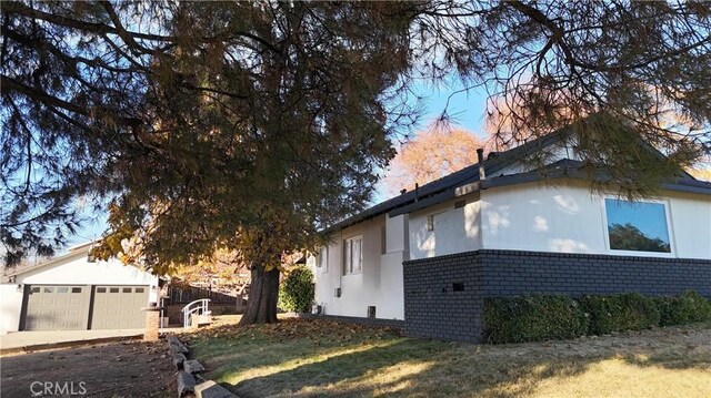 view of property exterior featuring a lawn and a garage