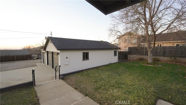 property exterior at dusk featuring a yard and a garage