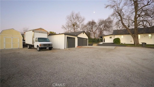 view of front of house with a garage and a storage unit