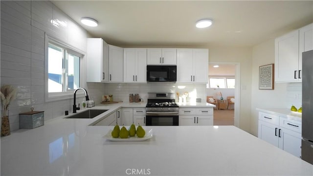 kitchen featuring sink, white cabinetry, backsplash, and stainless steel appliances