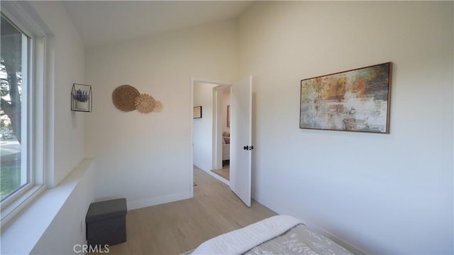 bedroom with light hardwood / wood-style flooring and vaulted ceiling