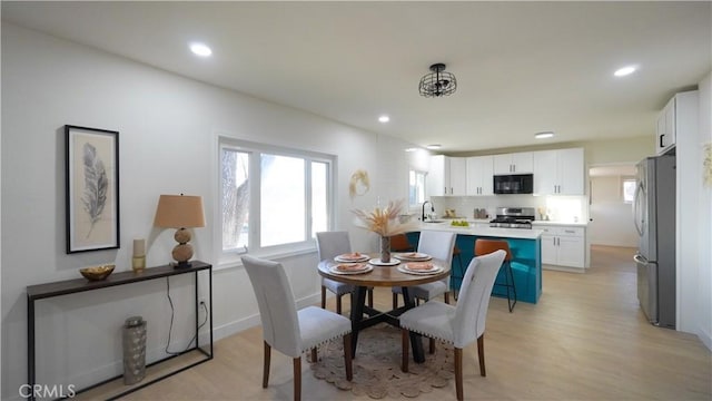 dining room with sink and light hardwood / wood-style floors